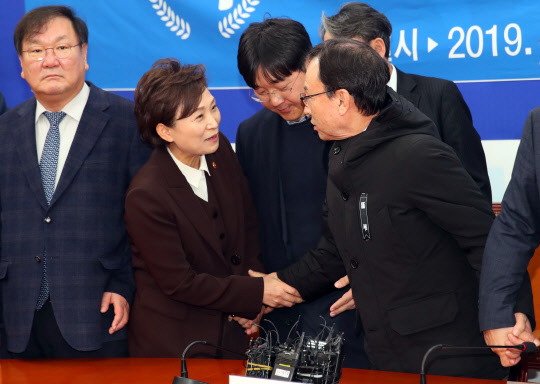 김현미 국토교통부 장관(왼쪽 두번째)과 박권수 전국개인택시운송사업조합연합회 회장이 22일 국회에서 열린 '택시-카풀 사회적 대타협기구' 출범식에서 악수를 하고 있다. 가운데는 정주환 카카오모빌리티 대표. 그러나 이날 출범식은 택시업계가 당정의 방침에 반발하면서 파투났다. 연합뉴스
